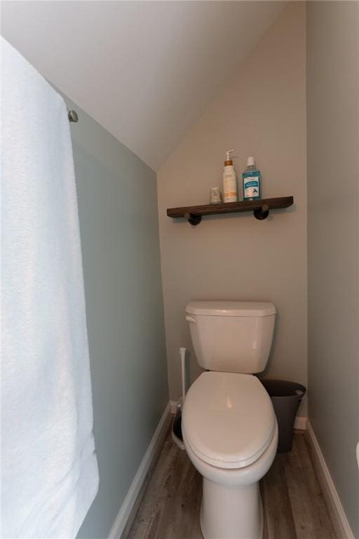 bathroom featuring lofted ceiling, wood finished floors, toilet, and baseboards