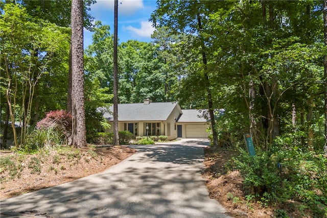 view of front of property with a garage, a chimney, and concrete driveway