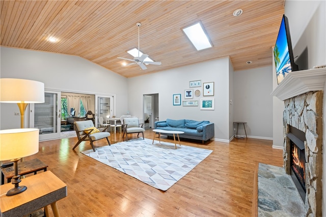 living room featuring vaulted ceiling, wood finished floors, ceiling fan, wooden ceiling, and a fireplace