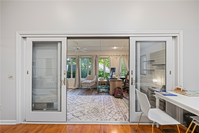 doorway with wood finished floors and ceiling fan