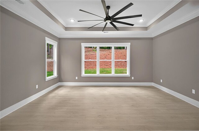 empty room featuring crown molding, baseboards, and light wood-style floors