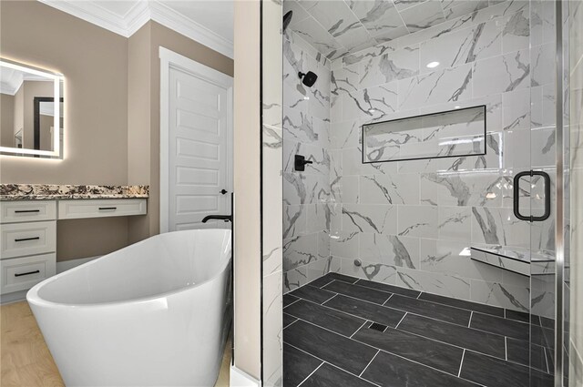 bathroom with a freestanding tub, a stall shower, crown molding, and vanity