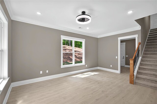 unfurnished living room featuring crown molding, light wood finished floors, visible vents, and stairway