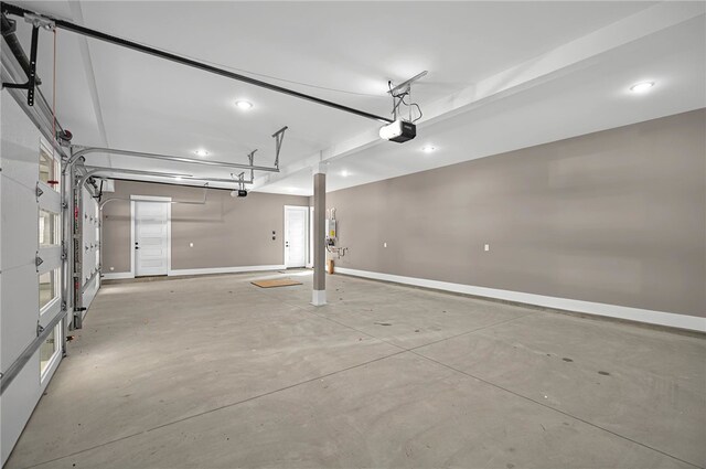 garage with a garage door opener, recessed lighting, and baseboards
