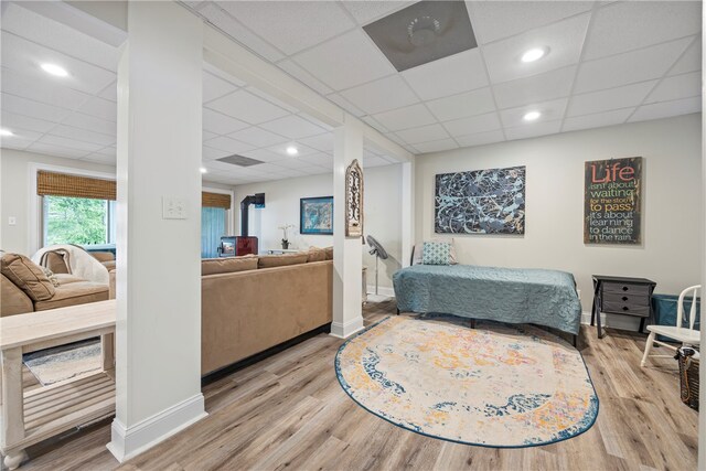 living room featuring baseboards, wood finished floors, and a paneled ceiling