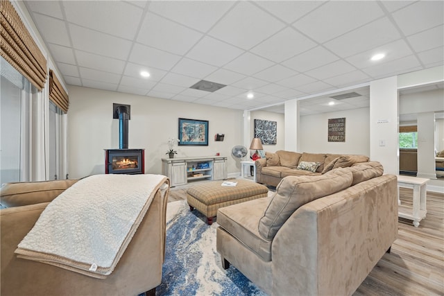 living area featuring a wood stove, a paneled ceiling, recessed lighting, and wood finished floors