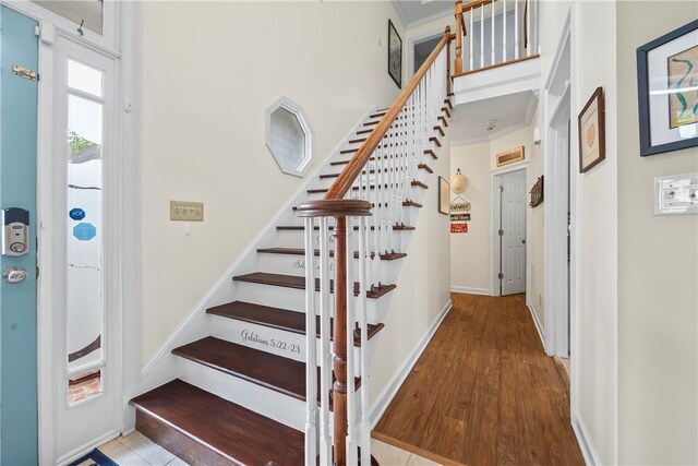 staircase featuring wood finished floors and baseboards