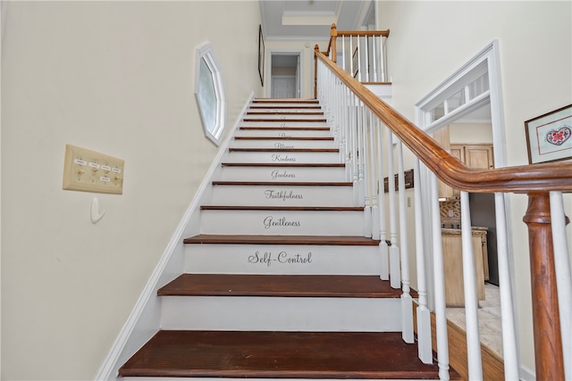 stairs featuring wood finished floors, a high ceiling, and ornamental molding