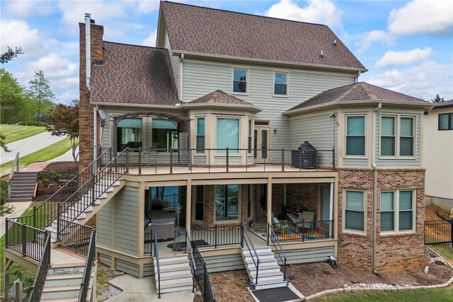 rear view of property featuring stairs, a chimney, and brick siding