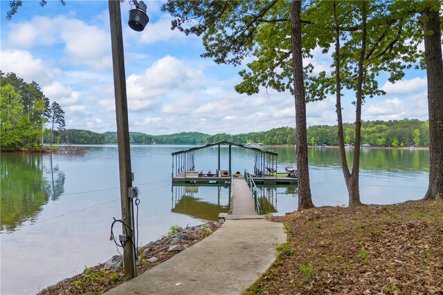 dock area featuring a water view and a wooded view