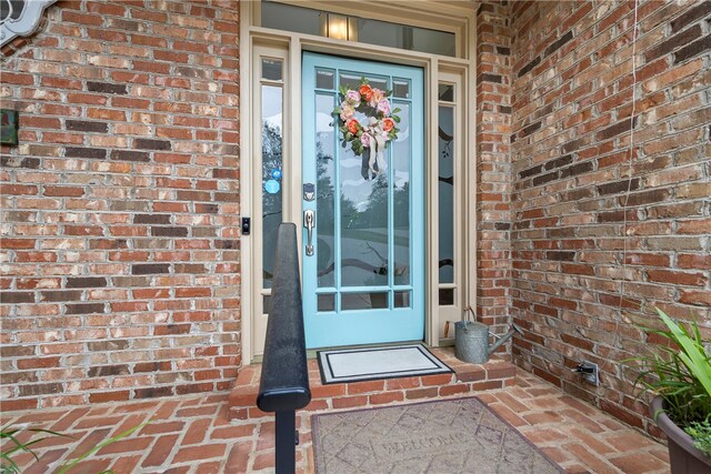 view of exterior entry with brick siding
