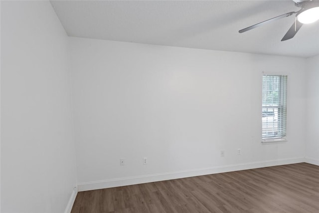 empty room featuring a ceiling fan, wood finished floors, and baseboards