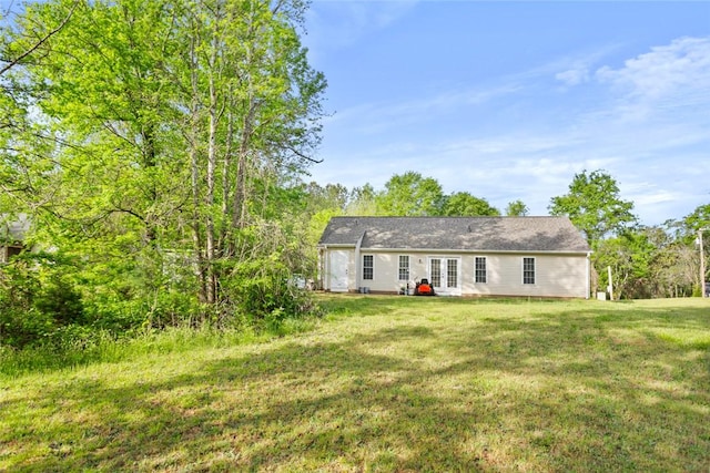 back of property featuring a yard and french doors