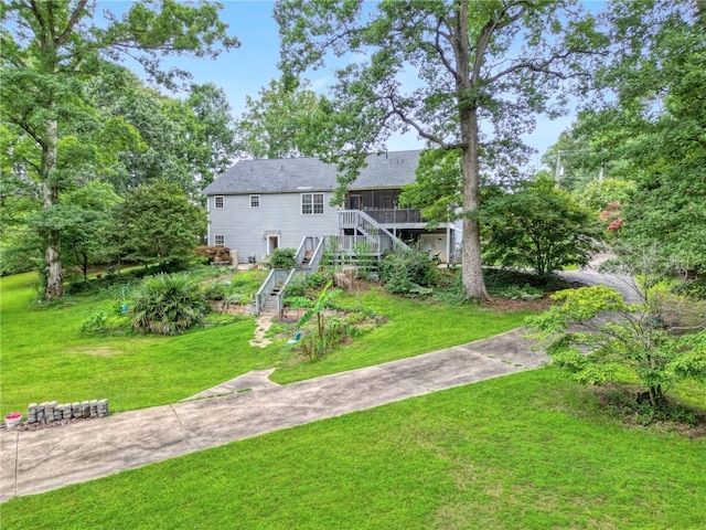 rear view of property featuring stairs and a yard