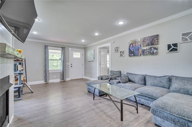 living area featuring wood finished floors, recessed lighting, ornamental molding, and baseboards