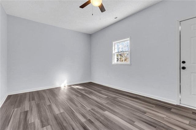 unfurnished room with wood finished floors, ceiling fan, visible vents, and baseboards