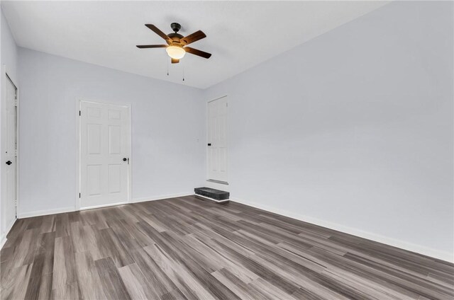 unfurnished room with wood finished floors, ceiling fan, and baseboards