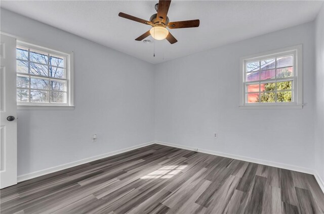 unfurnished room featuring ceiling fan, dark wood finished floors, and baseboards