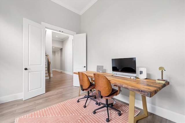 office area featuring wood finished floors, ornamental molding, and baseboards
