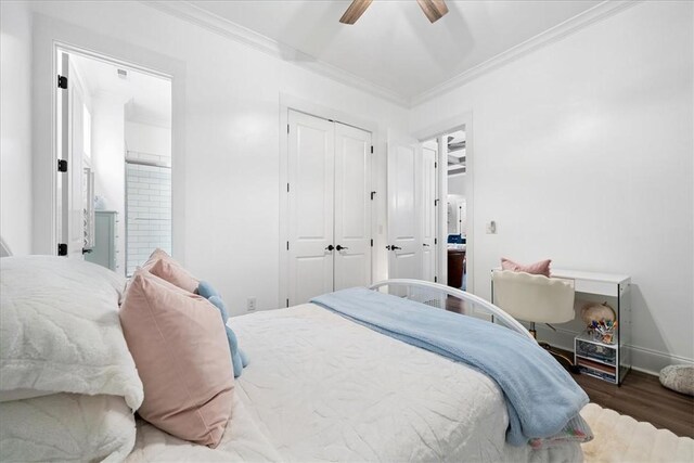 bedroom with wood finished floors, a closet, ornamental molding, and baseboards