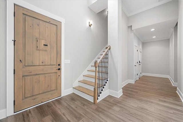 entrance foyer with recessed lighting, stairway, baseboards, ornamental molding, and wood finished floors
