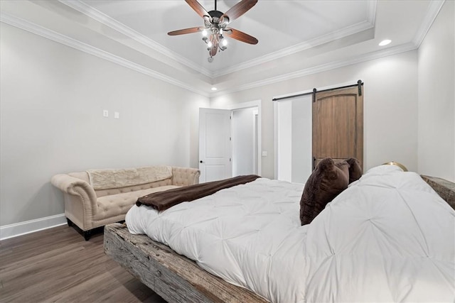 bedroom with crown molding, a tray ceiling, baseboards, recessed lighting, and wood finished floors