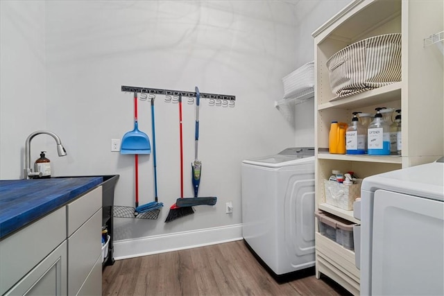 washroom featuring dark wood-style flooring, washing machine and clothes dryer, and baseboards