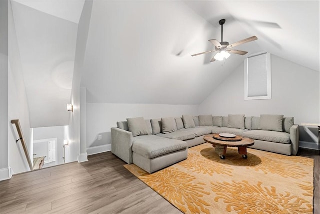 living area featuring ceiling fan, vaulted ceiling, wood finished floors, and baseboards