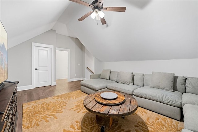 living room featuring lofted ceiling, wood finished floors, ceiling fan, and baseboards