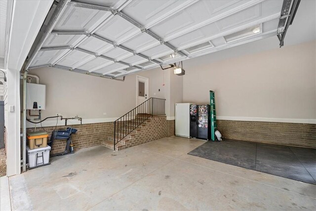 garage featuring fridge with ice dispenser, tankless water heater, and a garage door opener