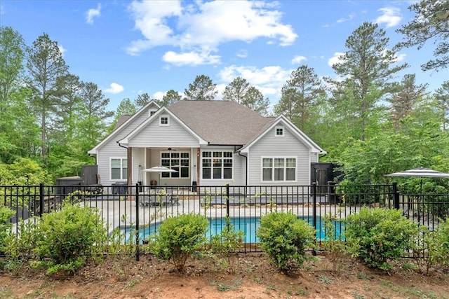 back of property featuring a patio, a ceiling fan, a fenced in pool, and fence