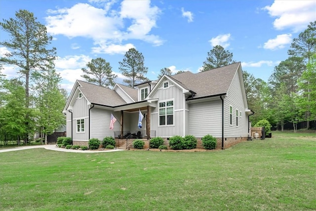 craftsman-style house with roof with shingles, board and batten siding, a front yard, and crawl space