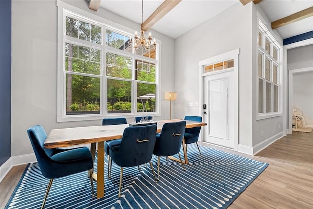 dining space with baseboards, beamed ceiling, a notable chandelier, and light wood-style floors