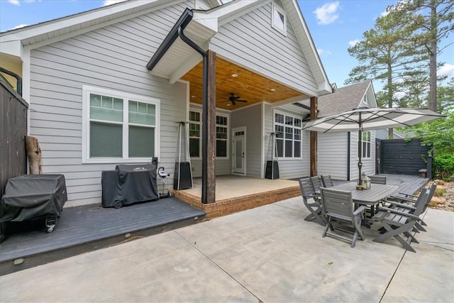back of property featuring a ceiling fan, a patio area, a wooden deck, and outdoor dining area