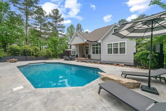 view of pool with fence, a fenced in pool, a wooden deck, and a patio area