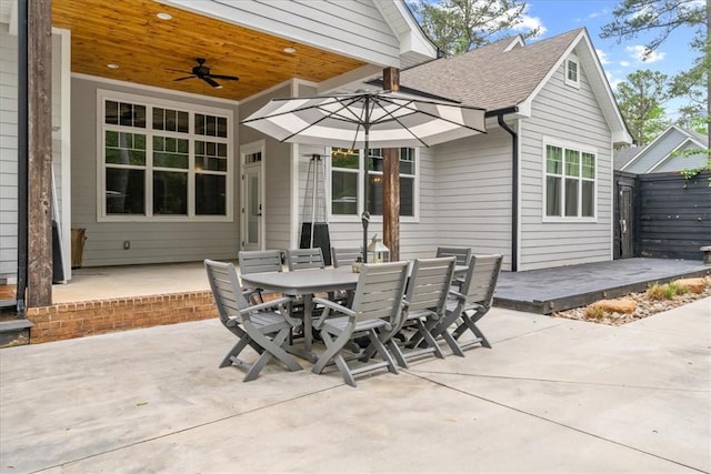 view of patio with fence, outdoor dining area, and a ceiling fan
