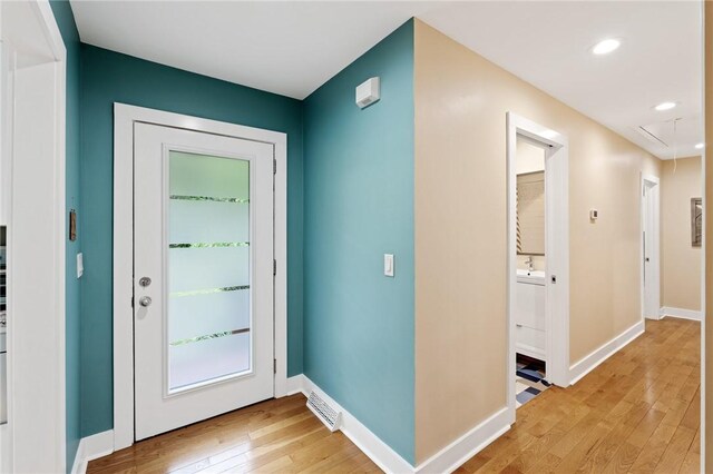 entryway featuring baseboards, light wood-type flooring, visible vents, and recessed lighting