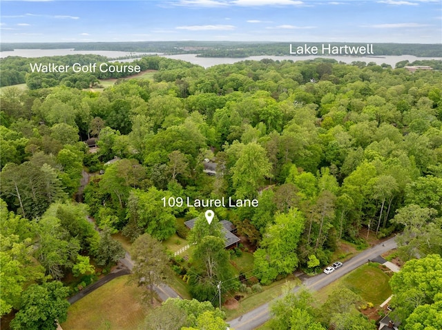 birds eye view of property with a wooded view and a water view
