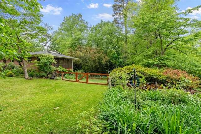 view of yard featuring a sunroom and fence