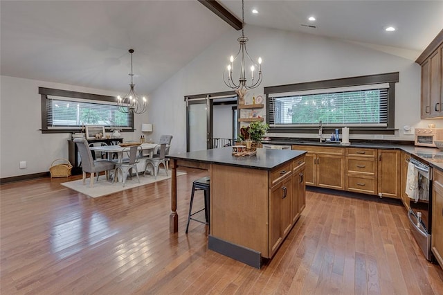 kitchen featuring a sink, dark countertops, a chandelier, a barn door, and dark wood finished floors