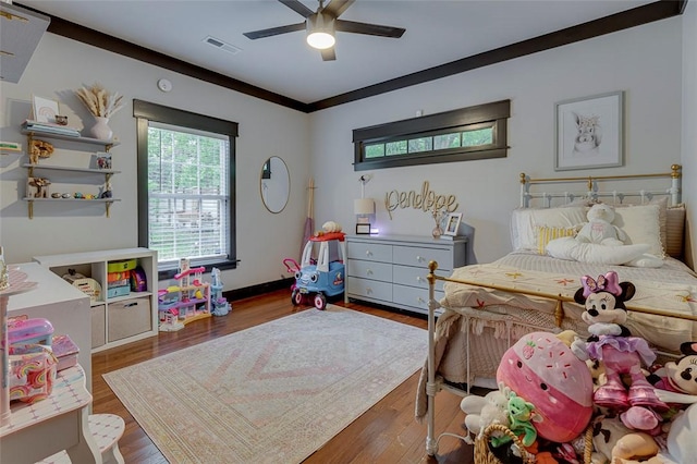 bedroom featuring a ceiling fan, visible vents, and wood finished floors