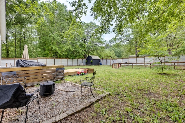 view of yard with an outdoor structure, a storage shed, and a fenced backyard