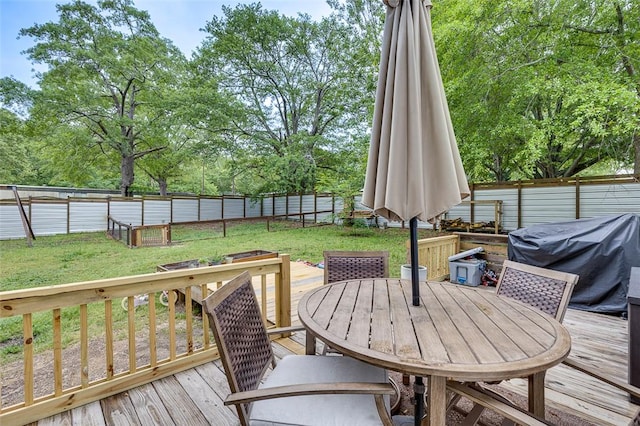 wooden deck featuring a fenced backyard, outdoor dining area, and a yard