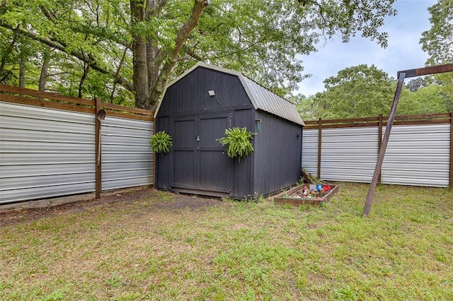 view of yard featuring a storage unit, a fenced backyard, and an outbuilding