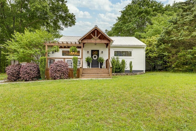 view of front facade featuring metal roof, a front yard, and a pergola