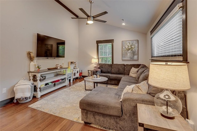 living area with visible vents, wood finished floors, a ceiling fan, and lofted ceiling