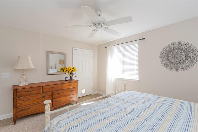 bedroom with ceiling fan, light carpet, and baseboards