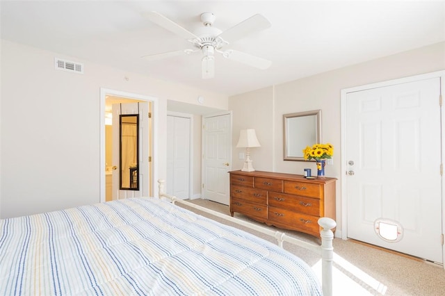 carpeted bedroom featuring visible vents, ceiling fan, and ensuite bath