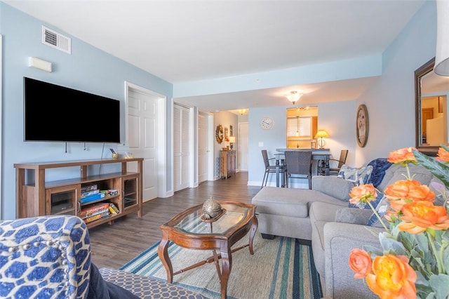 living area with visible vents and wood finished floors