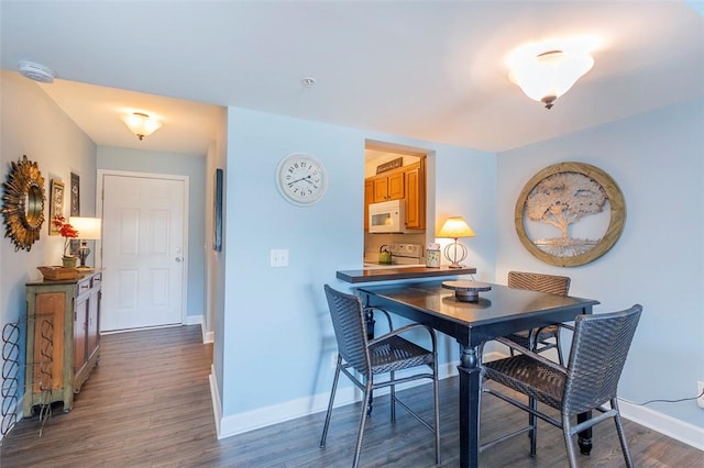 dining area featuring baseboards and dark wood finished floors